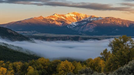 Obraz premium Stunning Snow-Capped Mountain Range Under Golden Sunrise Sky