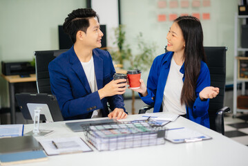 Two business worker standing and holding a coffee cup in modern office, successful, celebration,