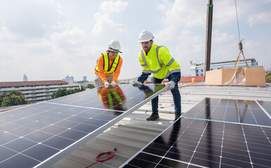 Men technicians carrying photovoltaic solar moduls on roof of factory on the morning. Installing a...