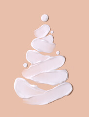 Christmas tree concept in the form of cosmetic strokes on a beige background. Skin hydration in winter. Winter concept.