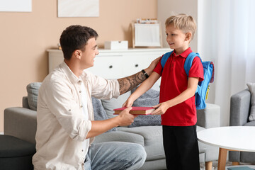 Obraz premium Father giving books to his little son at home
