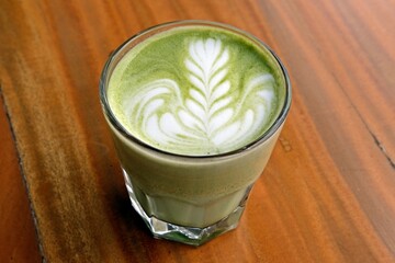 A beautifully crafted matcha latte in a clear glass, with delicate latte art on top. This creamy...