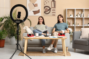 Young sisters with magazine recording podcast at home
