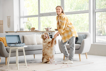 Young woman dancing with Australian Shepherd dog and record player at home