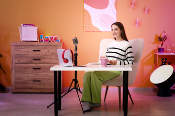 Young woman with clipboard recording podcast in studio