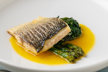 Grilled sea bass fillet served with garnishes in a fine dining restaurant