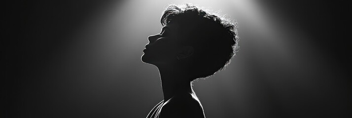Black and white silhouette of a woman's profile, lit from above.