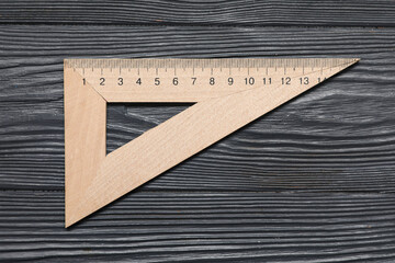 Triangle ruler on dark wooden background