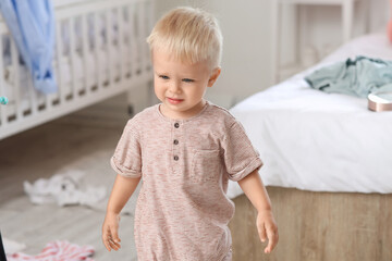 Fototapeta premium Naughty baby boy in messy bedroom