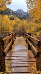 Fototapeta premium A serene wooden bridge surrounded by vibrant autumn foliage and mountains in the background.
