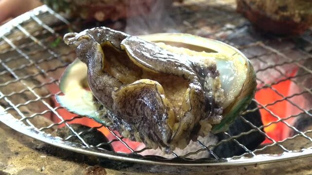 三重県産の殻付きアワビを炭火で踊り焼き クローズアップ  4K