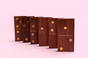 Wooden dominos blocks on pink background