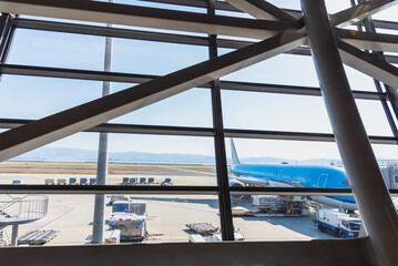Airport terminal glass window with view of airplane, airport interoir departure hall for travel and transportation concept.