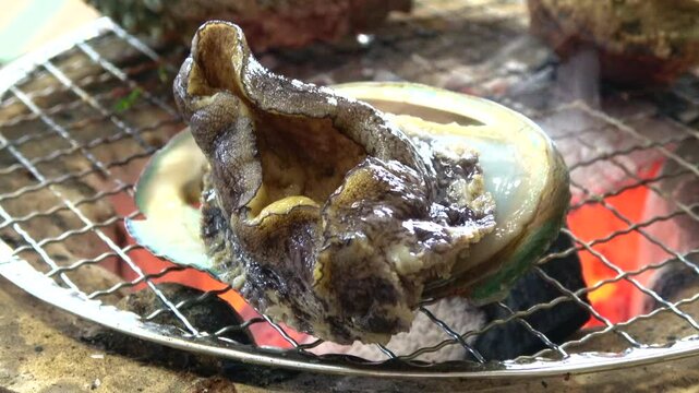 三重県産の殻付きアワビを炭火で踊り焼き クローズアップ  4K
