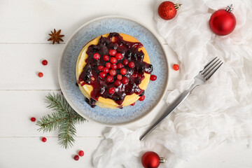 Plate of sweet pancakes with jam, fir branch and Christmas balls on white wooden background