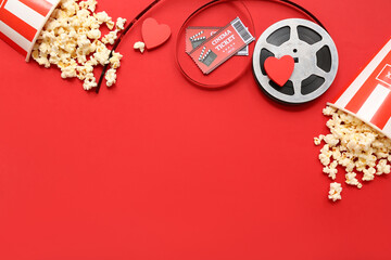 Buckets of popcorn with cinema tickets and film reel on red background. Valentine's Day celebration