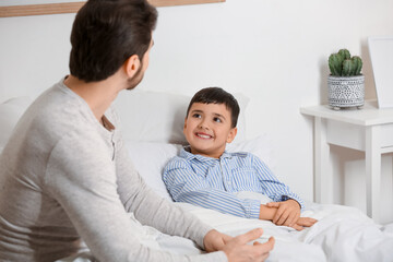 Father with his little son lying in bedroom
