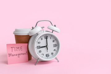 Sticky note with text TIME MANAGEMENT, alarm clock and cup of coffee on pink background
