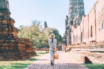 Rear view of woman walking visit at Ayutthaya temple historical destination, Thailand