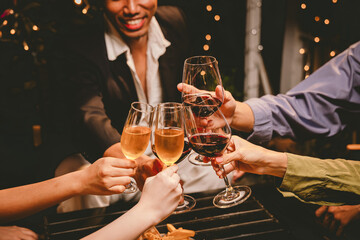 A group of friends enjoy an outdoor evening, drinking wine in a friendly and lively atmosphere. They celebrate togetherness, happiness and bonding.
