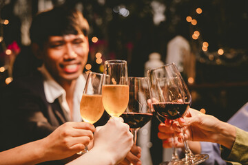 A group of friends enjoy an outdoor evening, drinking wine in a friendly and lively atmosphere. They celebrate togetherness, happiness and bonding.