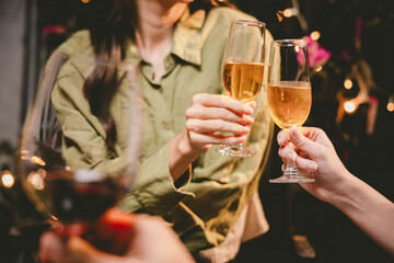 A group of friends enjoy an outdoor evening, drinking wine in a friendly and lively atmosphere. They celebrate togetherness, happiness and bonding.