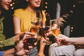 A group of friends enjoy an outdoor evening, drinking wine in a friendly and lively atmosphere. They celebrate togetherness, happiness and bonding.