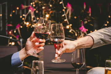 A group of friends enjoy an outdoor evening, drinking wine in a friendly and lively atmosphere. They celebrate togetherness, happiness and bonding.