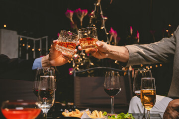 A group of friends enjoy an outdoor evening, drinking wine in a friendly and lively atmosphere. They celebrate togetherness, happiness and bonding.
