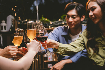 A cheerful group of friends enjoying wine and food on a sunny patio. Toasting with wineglasses, they celebrate togetherness in a scenic outdoor setting, blending fun, friendship, and a festive mood.