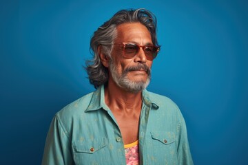 Obraz premium A man with a beard and glasses is wearing a blue shirt and sunglasses