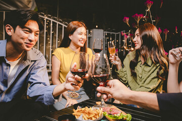 A joyful group of friends and family gathered around a dinner table, raising wine glasses in a celebratory toast. Smiling and laughing, they enjoy food, drinks, and togetherness in a festive atmospher