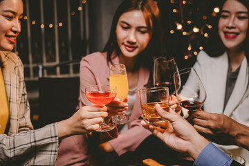 A group of cheerful friends enjoy drinks at a joyful celebration. They smile and laugh, sharing moments of happiness, togetherness and relaxation in a lively social atmosphere.