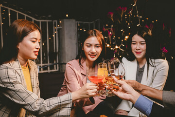 A group of cheerful friends enjoy drinks at a joyful celebration. They smile and laugh, sharing moments of happiness, togetherness and relaxation in a lively social atmosphere.