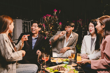 A group of cheerful friends enjoy drinks at a joyful celebration. They smile and laugh, sharing moments of happiness, togetherness and relaxation in a lively social atmosphere.