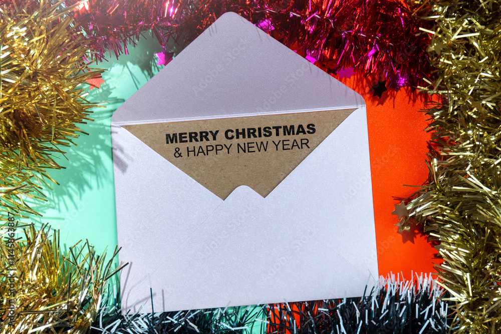 Poster closeup view of merry christmas and happy new year text on an envelope with a christmas ornament fra