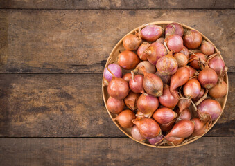 Shallots in a wood bowl on wooden background. selective focus
