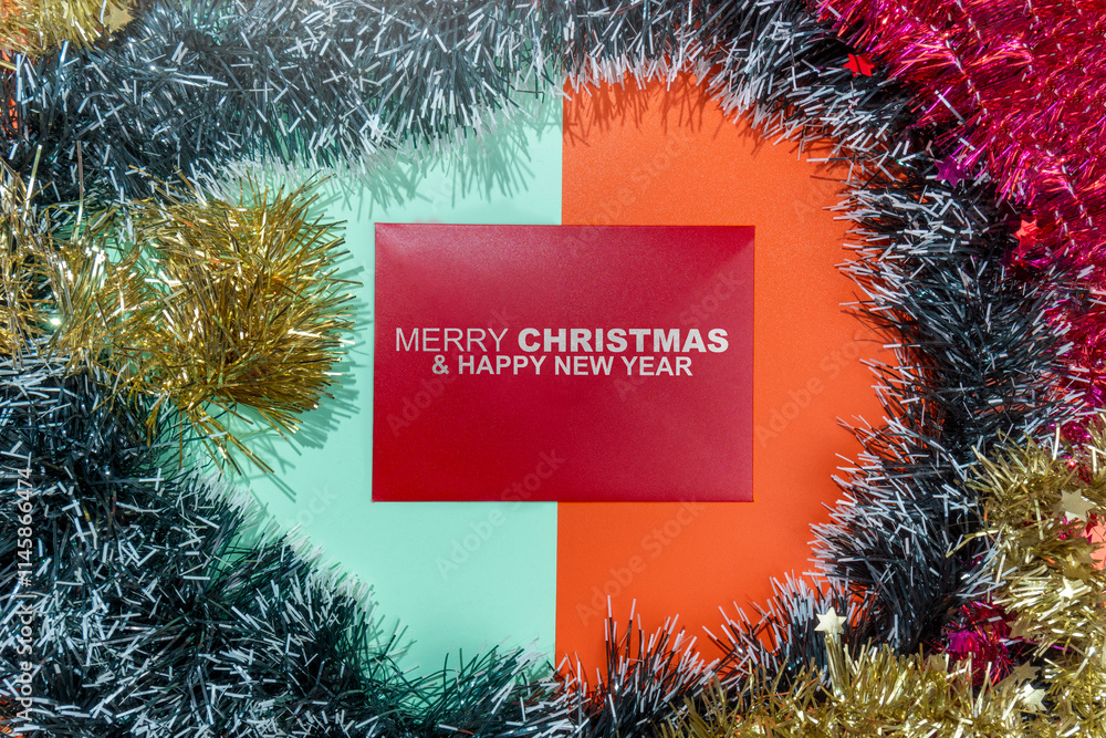 Poster closeup view of merry christmas and happy new year text on an envelope with a christmas ornament fra