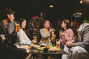 A lively group of friends enjoying beers at a festive pub, toasting with frosty pints. The scene captures the joy of friendship, culture, and celebration over drinks and appetizers on a sunny terrace.
