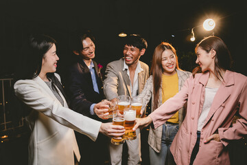 A group of cheerful friends celebrating, holding glasses of beer and laughing together. A lively gathering shows bonding, happiness and relaxation in a lively atmosphere.