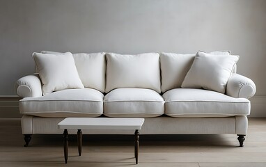 Off-white sofa with three cushions and a small white table in front.