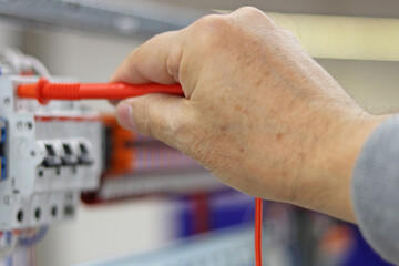 Measurement of electrical parameters in a switchboard using a multimeter.