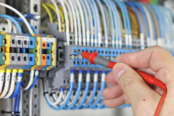 Measurement of electrical parameters in a switchboard using a multimeter.