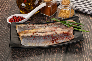 Salted marinated herring fillet with spices