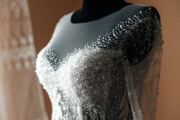 a mannequin wearing a dress with an ornate top. The dress is made of transparent fabric and...