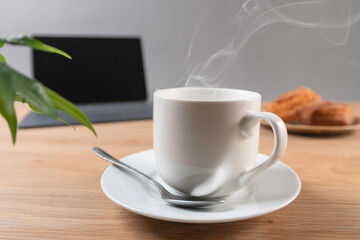 湯気の立つ温かいコーヒーとドーナツでコーヒーブレイク