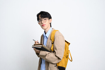 Portrait of male college student with glasses and backpack standing over white background