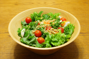 Vegetable salad with tomatoes, lettuce, nuts, eggs, etc. as ingredients.