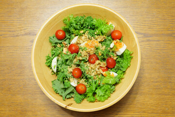 Vegetable salad with tomatoes, lettuce, nuts, eggs, etc. as ingredients.