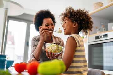 Healthy eating family and people concept. Happy mother and daughter having breakfast at home kitchen
